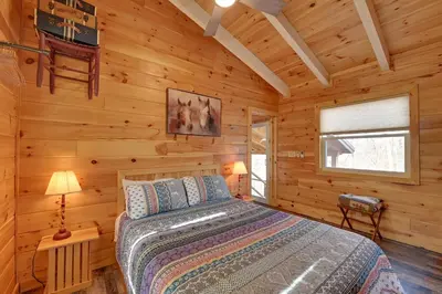 a bedroom with a bed in a log cabin at Bring a Pet Peaceful Frenchburg Cabin on 1 Acre in Frenchburg