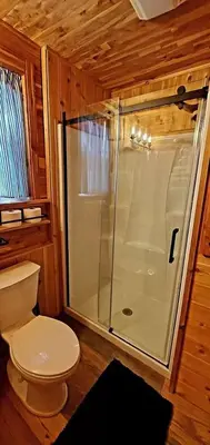 a bathroom with a shower and a toilet at Deer Haven Cabin in New Straitsville