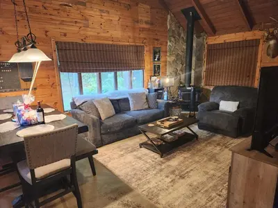 a living room with a couch and a table at Deer Haven Cabin in New Straitsville