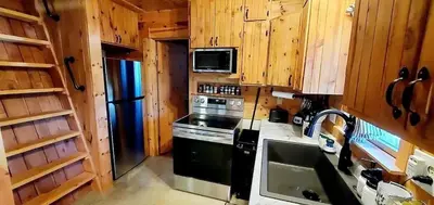 a kitchen with a stove and a refrigerator at Deer Haven Cabin in New Straitsville