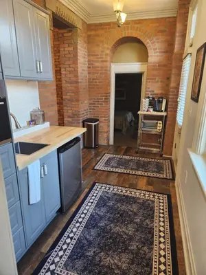 a kitchen with blue cabinets and a brick wall at Schwartz Castle in Columbus