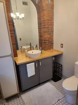 a bathroom with a sink and a brick wall at Schwartz Castle in Columbus