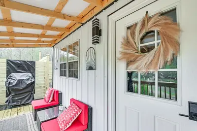 a front porch with red chairs and a wreath at Hot Tub, Fire Pit Lake-View Catlettsburg Getaway! in Catlettsburg