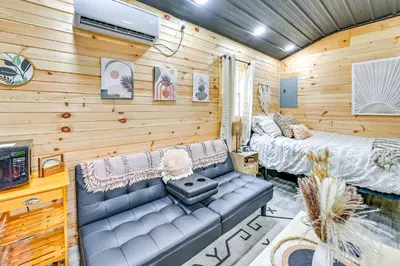 a room with a couch and a bed and a tv at Hot Tub, Fire Pit Lake-View Catlettsburg Getaway! in Catlettsburg