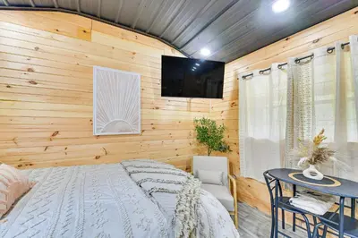 a bedroom with a bed and a tv on a wall at Hot Tub, Fire Pit Lake-View Catlettsburg Getaway! in Catlettsburg