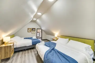 a attic bedroom with two beds and two lamps at 4 Mi to Dtwn Modern Retreat with Yard in Cleveland in Cleveland