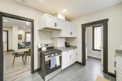 a kitchen with white cabinets and a stove top oven at 4 Mi to Dtwn Modern Retreat with Yard in Cleveland in Cleveland