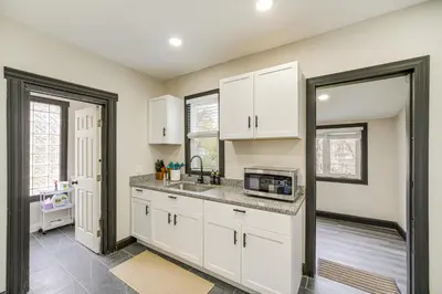 a kitchen with white cabinets and a sink at 4 Mi to Dtwn Modern Retreat with Yard in Cleveland in Cleveland