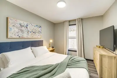 a bedroom with a large bed and a tv at 4 Mi to Dtwn Modern Retreat with Yard in Cleveland in Cleveland