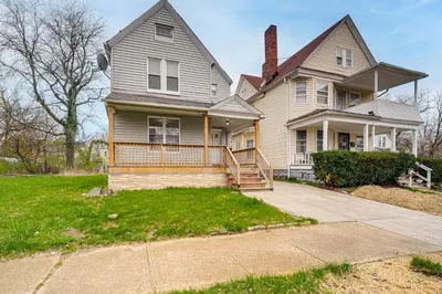 a large house with a porch and a driveway at 4 Mi to Dtwn Modern Retreat with Yard in Cleveland in Cleveland