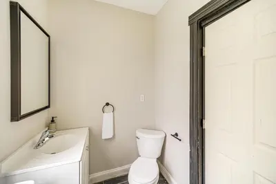a bathroom with a toilet and a sink and a mirror at 4 Mi to Dtwn Modern Retreat with Yard in Cleveland in Cleveland