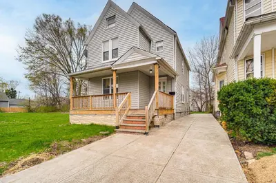 a large house with a porch and a sidewalk at 4 Mi to Dtwn Modern Retreat with Yard in Cleveland in Cleveland