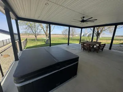 a screened in porch with a table and a ceiling fan at Country Cornerstone Retreat - Game Room, Theater, Hot Tub, Massage Chairs, Gym, Grill, Sauna, Fire Pit in Hillsboro
