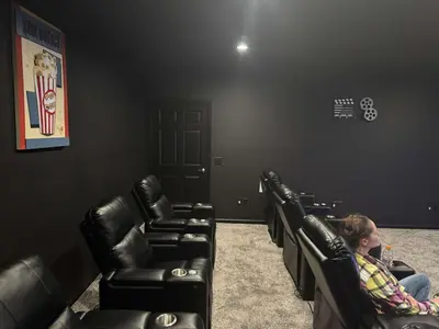 a woman sitting in a waiting room with black leather chairs at Country Cornerstone Retreat - Game Room, Theater, Hot Tub, Massage Chairs, Gym, Grill, Sauna, Fire Pit in Hillsboro