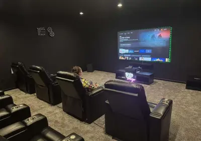a child sitting in a chair in front of a screen at Country Cornerstone Retreat - Game Room, Theater, Hot Tub, Massage Chairs, Gym, Grill, Sauna, Fire Pit in Hillsboro