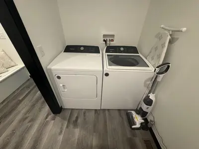 a small kitchen with a stove and a vacuum at Country Cornerstone Retreat - Game Room, Theater, Hot Tub, Massage Chairs, Gym, Grill, Sauna, Fire Pit in Hillsboro