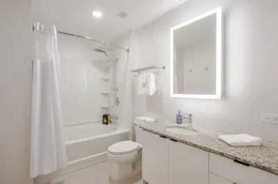 a white bathroom with a toilet and a shower at CozySuites at Sky Central in Cincinnati