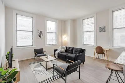 a living room with a black couch and chairs at CozySuites at Sky Central in Cincinnati