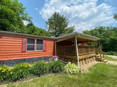 a cabin with a deck with a porch at 2 Bedroom Logan Ohio Hot Tub in Logan