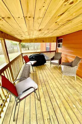 a room with chairs and a table on a wooden deck at 2 Bedroom Logan Ohio Hot Tub in Logan