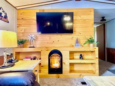 a room with a wooden wall with a fireplace at 2 Bedroom Logan Ohio Hot Tub in Logan