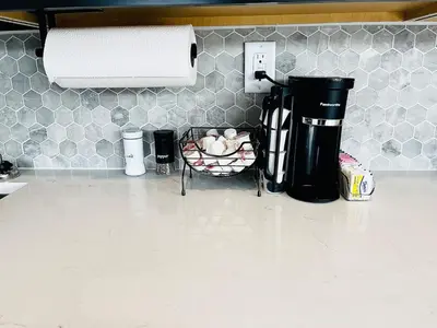a kitchen counter with a coffee maker and a basket of onions at The 419 Ten-Room Boutique in Sandusky in Sandusky