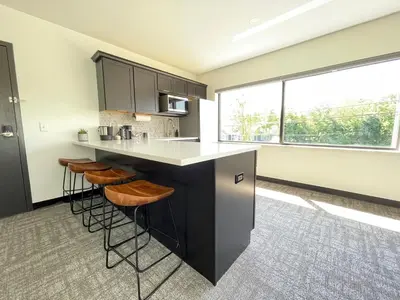 a kitchen with a black island with stools at The 419 Ten-Room Boutique in Sandusky in Sandusky