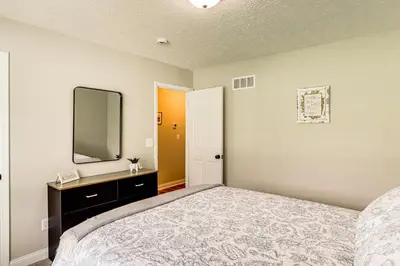 a bedroom with a large bed and a mirror at Deck and Outdoor Dining Family Getaway in Dry Ridge in Dry Ridge