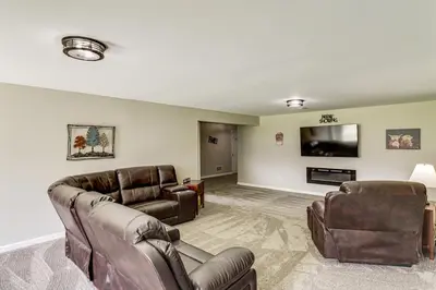a living room with leather furniture and a flat screen tv at Deck and Outdoor Dining Family Getaway in Dry Ridge in Dry Ridge