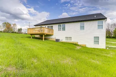 a house with a deck on a grassy hill at Deck and Outdoor Dining Family Getaway in Dry Ridge in Dry Ridge