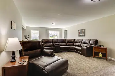 a living room with a leather couch and a table at Deck and Outdoor Dining Family Getaway in Dry Ridge in Dry Ridge
