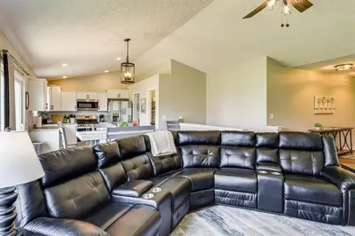 a living room with a leather couch and a kitchen at Deck and Outdoor Dining Family Getaway in Dry Ridge in Dry Ridge
