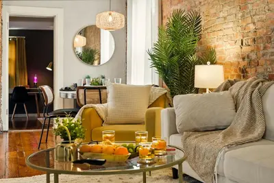 a living room with a couch and a table with oranges on it at Walk to OSU & Short North FREE PARKING Fire Pit in Columbus