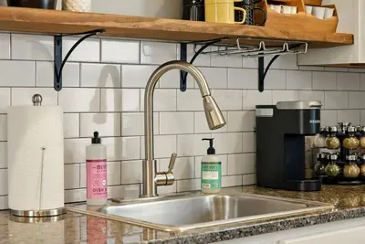a kitchen sink with two bottles of soap and aounter at Walk to OSU & Short North FREE PARKING Fire Pit in Columbus