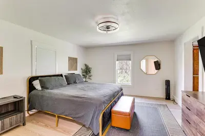 a bedroom with a bed and a flat screen tv at 3 Mi to Downtown Youngstown Apt with Deck! in Youngstown