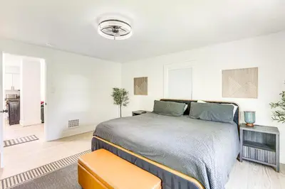 a bedroom with a bed in a white room at 3 Mi to Downtown Youngstown Apt with Deck! in Youngstown