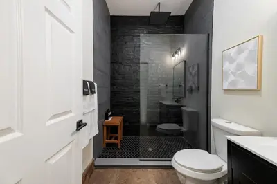 a bathroom with a shower with a toilet and a sink at Modern Loft-Style Retreat Near Blenko Glass in Milton, WV in Hurricane