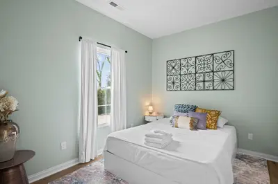 a bedroom with a white bed and a window at 4 apartments 10 bedrooms - 2 and a half Miles from Ark in Williamstown