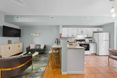 a kitchen and living room with white appliances at 4 apartments 10 bedrooms - 2 and a half Miles from Ark in Williamstown