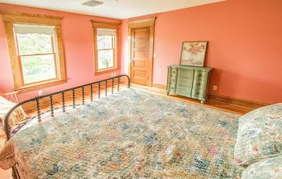 a bedroom with orange walls and a bed in a room at Nature Valley Farm- 2BD/1BA on private 53 acres in North Lawrence