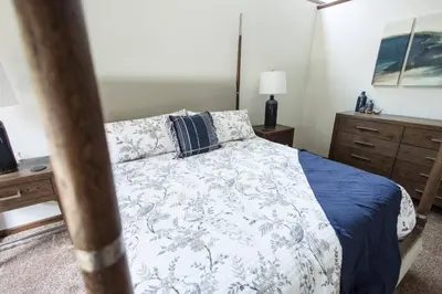 a bedroom with a bed with a blue and white comforter at Sherwood Forest Park- 6BD/3BA on Private Ohio Land in North Lawrence