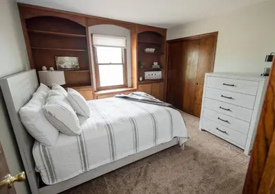 a bedroom with a bed and a dresser and a window at Sherwood Forest Park- 6BD/3BA on Private Ohio Land in North Lawrence