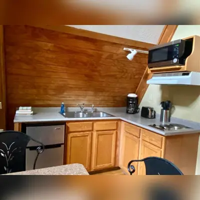 a small kitchen with a sink and a microwave at A-Frame #01 - by The Chalets in Logan