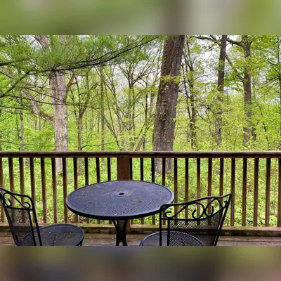 a table and chairs sitting on a porch with a table and chairs at A-Frame #02 - by The Chalets in Logan