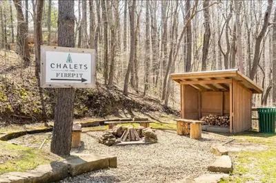 a sign for a chates fire pit in the woods at A-Frame #02 - by The Chalets in Logan