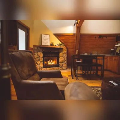 a living room with a couch and a fireplace at A-Frame #03 - by The Chalets in Logan