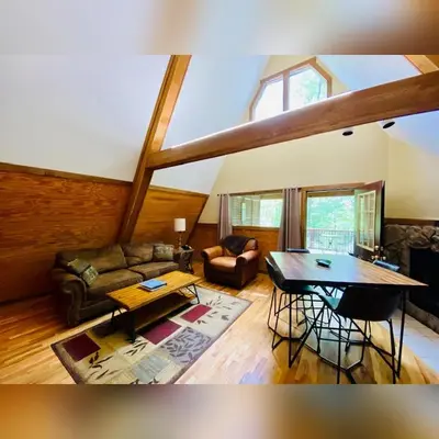 a living room with a couch and a table at A-Frame #04 - by The Chalets in Logan