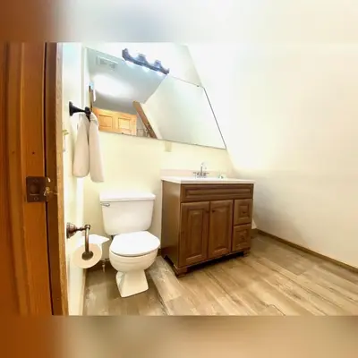 a bathroom with a white toilet and a sink at A-Frame #04 - by The Chalets in Logan