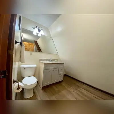 a bathroom with a toilet and a sink and a mirror at A-Frame #05 - by The Chalets in Logan