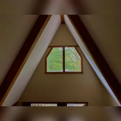 a window in the roof of a attic at A-Frame #06 - by The Chalets in Logan